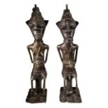 A PAIR OF 19TH CENTURY BRONZE YORUBA OGBONI EDAN FIGURES, NIGERIA In seated positions of Onile,