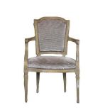 A LOUIS XVI DESIGN CARVED WOOD AND UPHOLSTERED ARMCHAIR The shaped back above scrolling arms and