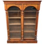 A LARGE 19TH CENTURY WALNUT FLOORSTANDING BOOKCASE With a pair of arch glazed doors opening to