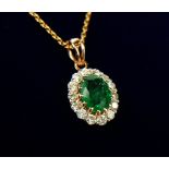 AN 18CT YELLOW GOLD, OVAL EMERALD AND DIAMOND CLUSTER PENDANT & CHAIN, the chain set with two