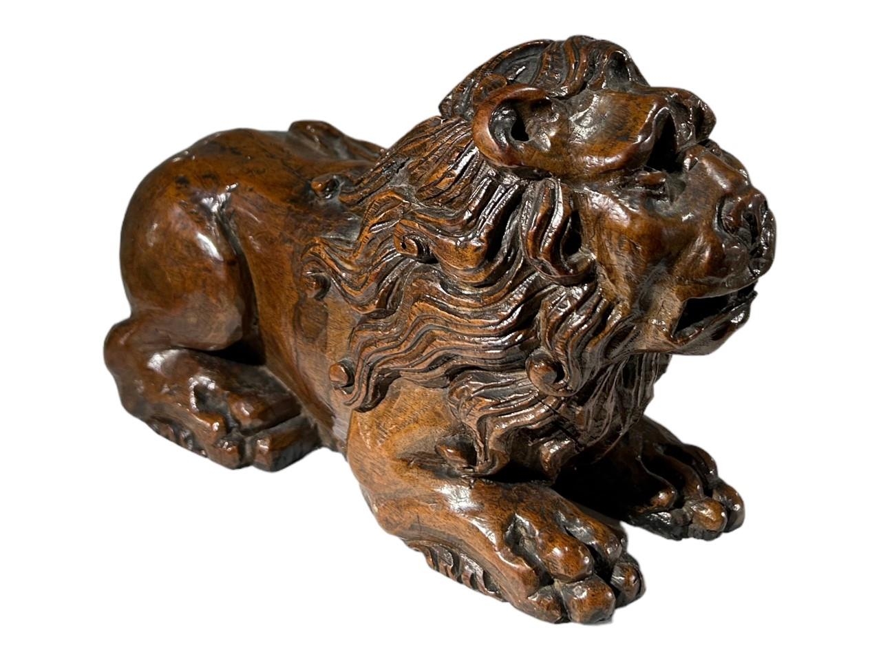 AN ITALIAN 18TH/19TH CENTURY (POSSIBLY WALNUT) CARVED WOOD FIGURE OF A LION. (h 12.5cm x w 20cm x