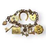 A VINTAGE 9CT GOLD CHARM BRACELET The oval pierced links set with eight charms including a St.