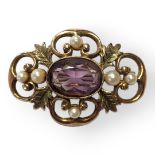 AN EARLY 20TH CENTURY 9CT GOLD, AMETHYST AND PEARL BROOCH The central oval cut amethyst flanked by