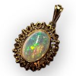 A VINTAGE 18CT GOLD AND OPAL PENDANT The cabochon oval cut opal in a pierced gold mount and