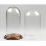 TWO VICTORIAN GLASS DISPLAY DOMES, ONE WITH LATER WOODEN BASE. Largest (h 29cm x w 17.5cm x d 17.