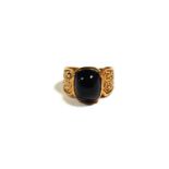 A VICTORIAN 9CT GOLD AND AMETHYST CABOCHON RING Having decorative chased shoulders and band. (UK