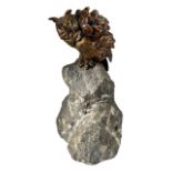 A LARGE 20TH CENTURY BRONZE OF AN OWL MOUNTED ON NATURALISTIC ROCK BASE Having a yellow glass