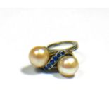 A 14CT WHITE GOLD, PEARL AND BLUE SPINEL CROSSOVER RING. (pearl diameter approx 8mm, UK ring size N,