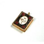 AN ISLAMIC YELLOW METAL AND ENAMEL QURAN PENDANT, TESTED AS 18CT GOLD. (23mm x 16mm, gross weight
