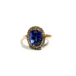 A POLISH 14CT ROSE GOLD, TOPAZ AND DIAMOND RING Central oval cut topaz in bezel mount, surrounded by