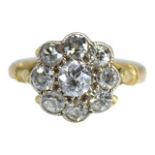 AN EDWARDIAN YELLOW METAL & DIAMOND CLUSTER RING, YELLOW METAL TESTED AS 18CT GOLD. Central bezel