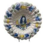 A LATE 17TH CENTURY DUTCH DELFTWARE LOBED FAIENCE CHARGER Painted in blue, green and yellow with a