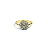 AN 18CT GOLD AND DIAMOND SOLITAIRE STYLE CLUSTER RING Having central bezel set brilliant diamond