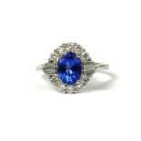 AN 18CT WHITE GOLD OVAL TANZANITE AND DIAMOND CLUSTER RING. (Approx, Tanzanite 1.19ct, Diamonds 0.