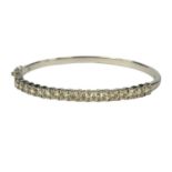 A 9CT WHITE GOLD BANGLE, set with round brilliant cut diamonds. (Diamonds 2.21ct, boxed)