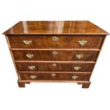 AN 18TH CENTURY WALNUT CHEST Of four long drawers fitted with brass handles and escutcheons,