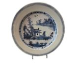 AN 18TH CENTURY DELFT PLATE Painted in blue and white with central cottage in a chinoiserie