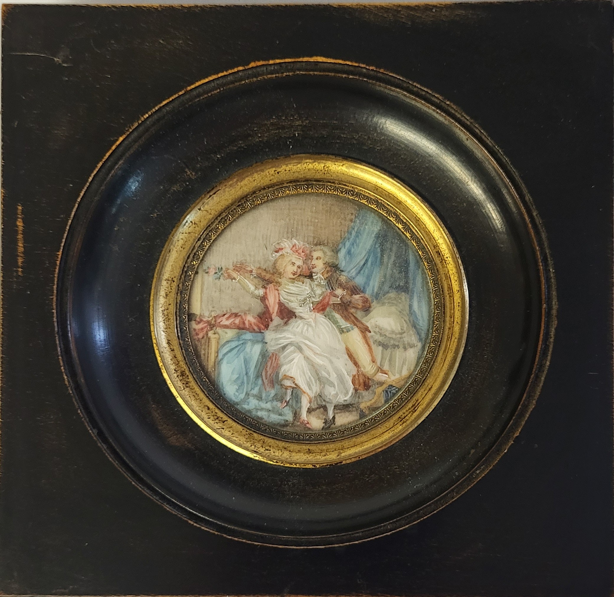 A 19TH CENTURY CIRCULAR MINIATURE PAINTING ON IVORY, BEDROOM SCENE WITH COURTING COUPLE In an