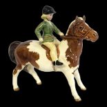 BESWICK, A VINTAGE PORCELAIN 'SKEWBALL' PONY AND RIDER Young girl wearing a black hat and green