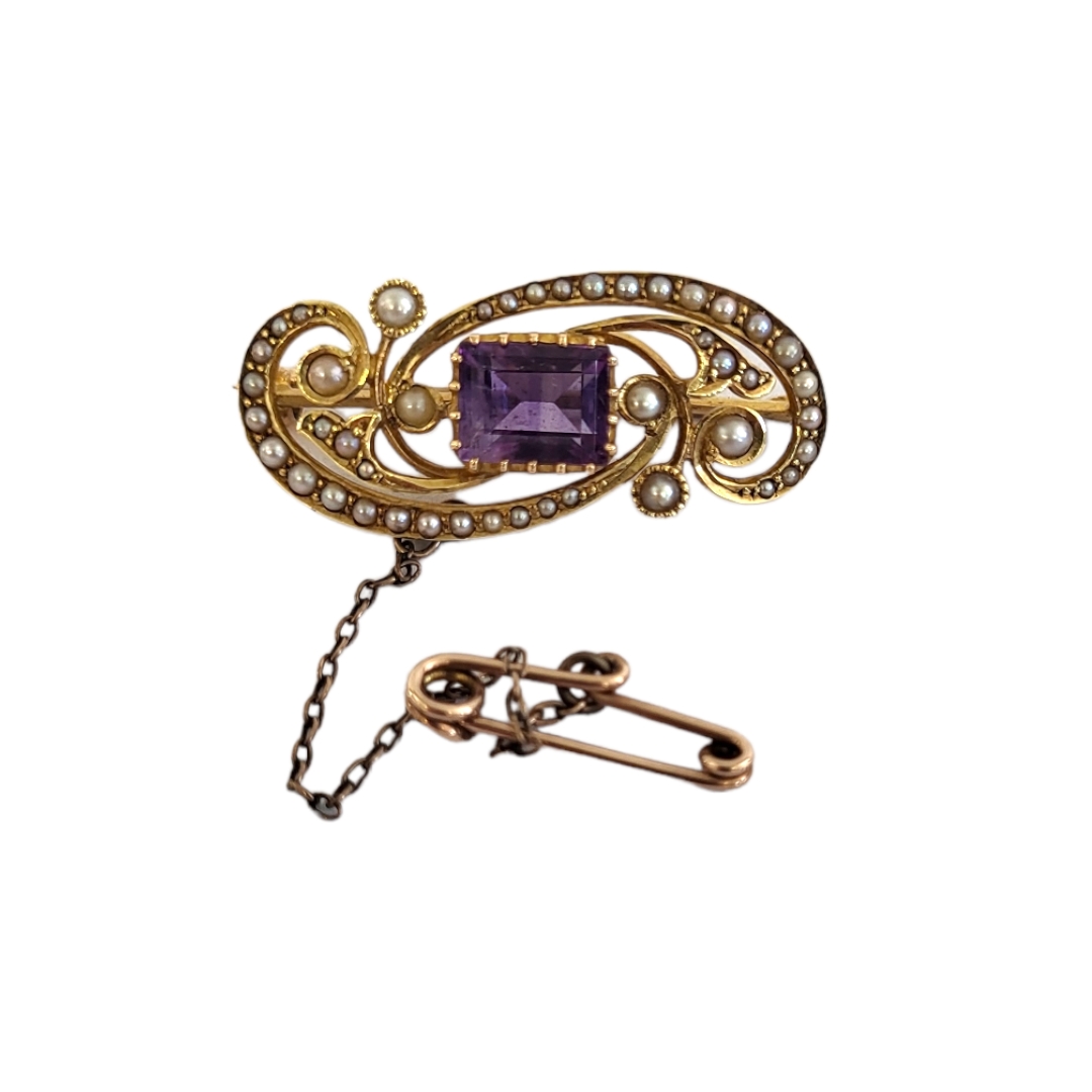 A LATE 19TH/EARLY 20TH CENTURY 15CT GOLD, AMETHYST AND SEED PEARL BROOCH The central baguette cut