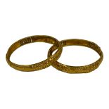 TWO CONTINENTAL YELLOW METAL BANGLES Having engraved and pierced decoration. Tests as 21 ct. (approx