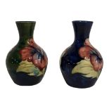 MOORCROFT, TWO MID 20th CENTURY POTTERY VASES tubeline decoration of Hibiscus one blue ground