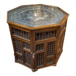 AN EARLY 20TH CENTURY OAK ISLAMIC HEXAGONAL TABLE the glazed top enclosing a polished brass tray,