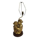 A VINTAGE BRASS MONKEY LAMP Two mobiles in embracing pose on a circular oak base. (monkoes 25cm)