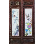 A PAIR OF LATE 20TH CENTURY CHINESE HARDWOOD MOUNTED PORCELAIN PLAQUES Depicting a group of Oriental