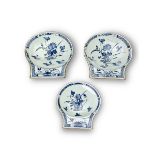 A Set of Three blue and white Dishes, Kangxi, of shell form with ribbed unglazed backs, each painted