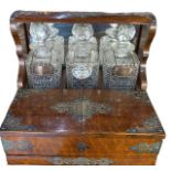 A VICTORIAN WOODEN AND BRASS TANTALUS SET, HAVING WHISKEY AND BRANDY SILVER DECANTER LABELS,