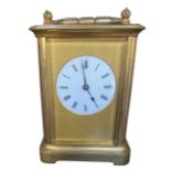 AN EARLY TO MID 20TH CENTURY YELLOW METAL CARRIAGE CLOCK Having engine front front plate, white dial