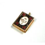 AN ISLAMIC YELLOW METAL AND ENAMEL QURAN PENDANT, TESTED AS 18CT GOLD.