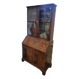 AN EARLY 18TH CENTURY WALNUT BUREAU BOOKCASE With two glazed doors above a fall front writing