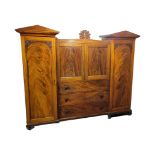 A WILLIAM IV PERIOD FLAME MAHOGANY ARCHITECTURAL TRIPLE WARDROBE With pointed arch cornice, above