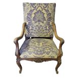 A WILLIAM AND MARY STYLE CARVED WALNUT OPEN ARMCHAIR In floral tapestry upholstery above a shaped