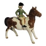 BESWICK, A VINTAGE PORCELAIN 'SKEWBALL' PONY AND RIDER Young girl wearing a black hat and green