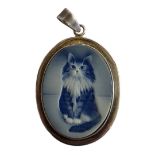 A VINTAGE SILVER AND PORCELAIN OVAL PENDANT With a pât-sur-pât porcelain study of a cat. (approx 4cm