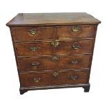 AN 18TH CENTURY OAK CHEST OF TWO SHORT ABOVE THREE LONG DRAWERS With brass handles, on bracket feet.