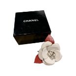 CHANEL, A CREAM AND RED STYLISED FLOWER HEAD BROOCH In original box.