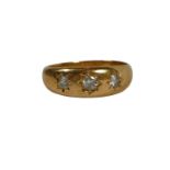 A LARGE 18CT GOLD, THREE STONE DIAMOND GYPSY SET RING The central diamond having old European