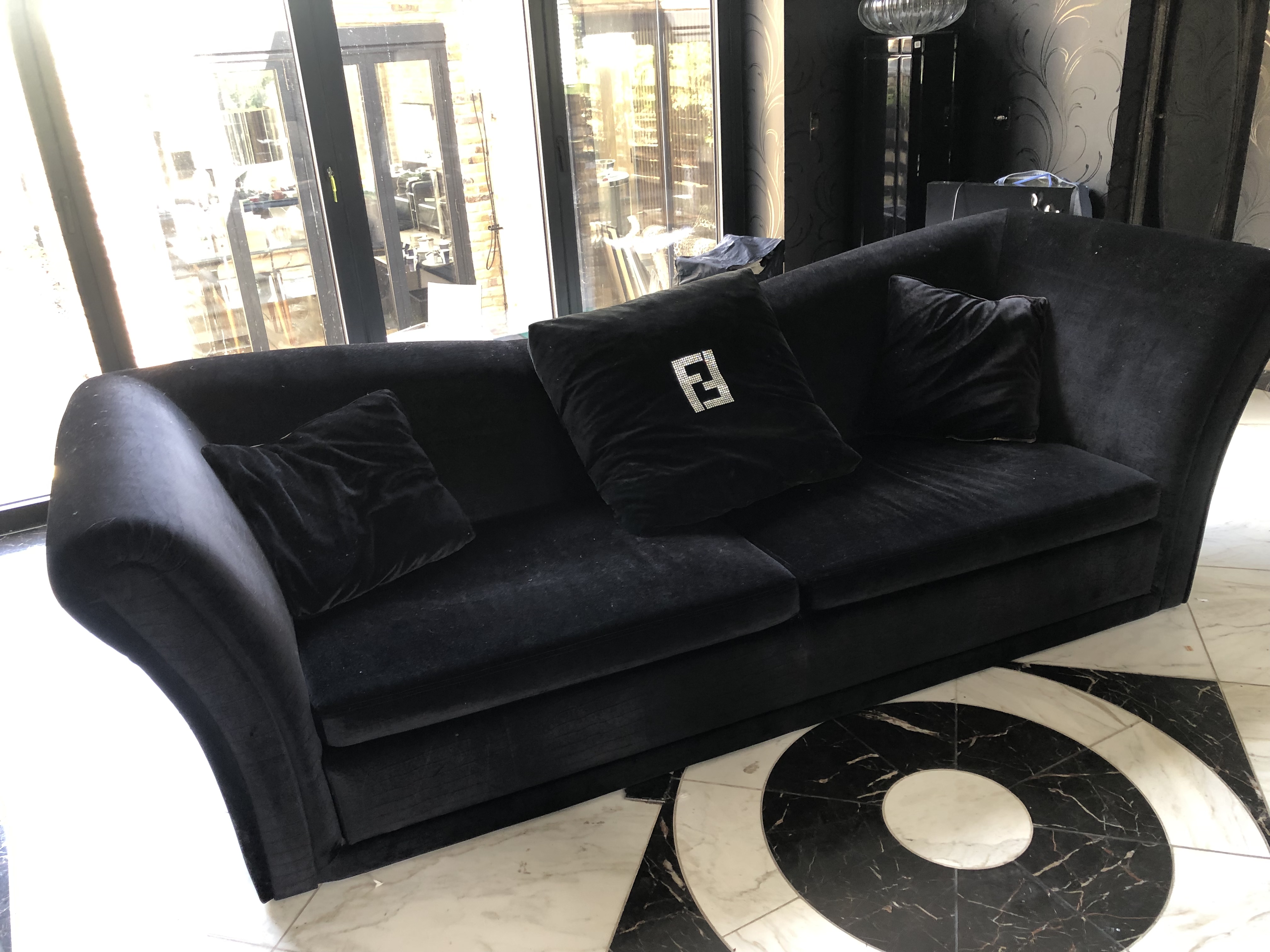 FENDI, A BLACK VELVET UPHOLSTERED THREE SEAT SETTEE With sunken back and scroll ends. (286cm x 105cm