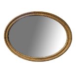 AN EDWARDIAN OVAL GILT FRAMED MIRROR. (96cm x 75cm)