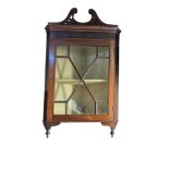 AN EARLY 20TH CENTURY MAHOGANY CORNER CABINET Having a pierced arched top with carved decoration and