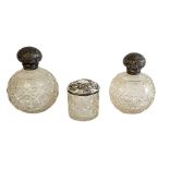 A PAIR OF EDWARDIAN SILVER AND CUT GLASS PERFUME BOTTLES Having dome form screw caps and cut glass