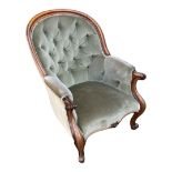 A VICTORIAN ROSEWOOD SPOONBACK ARMCHAIR In green velvet button back upholstery and scroll arms,