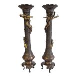 A PAIR OF 19TH CENTURY JAPANESE MEIJI BRONZE DRAGON CANDLESTICKS Having scalloped sconces and