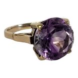 A VINTAGE YELLOW METAL AND AMETHYST RING a faceted round cut amethyst stone in plain mount. In