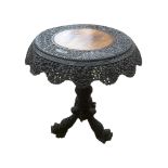 A 19TH CENTURY BURMESE TILT TOP CARVED TEAK SIDE TABLE The circular top with pierced apron, on