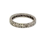 A WHITE METAL AND DIAMOND FULL ETERNITY RING Having a row of twenty-one round cut diamonds. (